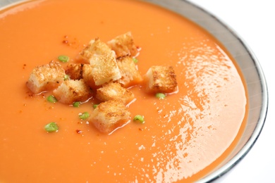 Tasty creamy pumpkin soup with croutons in bowl on white background, closeup