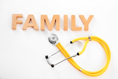 Word Family made of wooden letters and stethoscope on white background