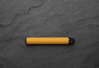 Disposable electronic smoking device on black background, top view