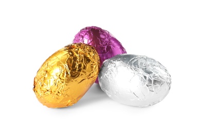 Chocolate eggs wrapped in colorful foil on white background