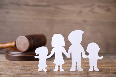 Family figure and judge gavel on wooden table. Family law concept