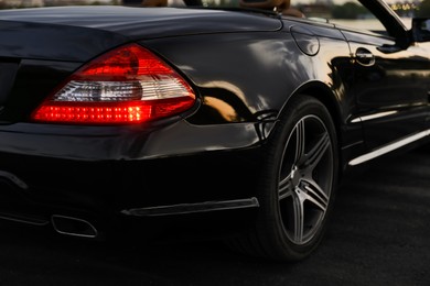 Photo of Luxury black convertible car outdoors in evening, closeup
