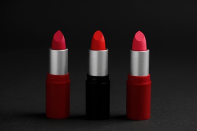 Different lipsticks on black background. Cosmetic product