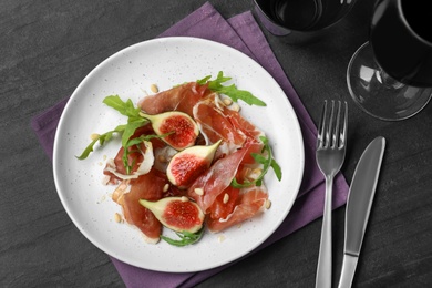 Photo of Delicious figs and proscuitto on plate, flat lay
