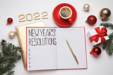 Making New Year's resolutions. Flat lay composition with notebook, 2022 numbers and festive decor on white background