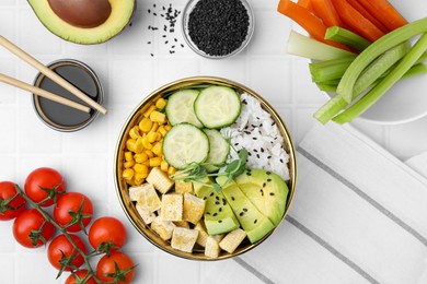 Photo of Delicious poke bowl and ingredients on white tiled table, flat lay
