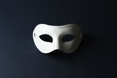 White theatre mask on black background, top view