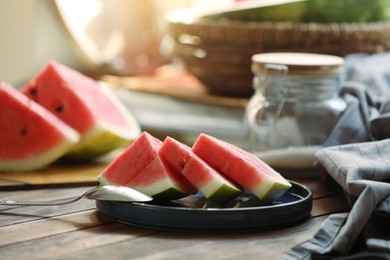 Sliced fresh juicy watermelon and spoon on wooden table