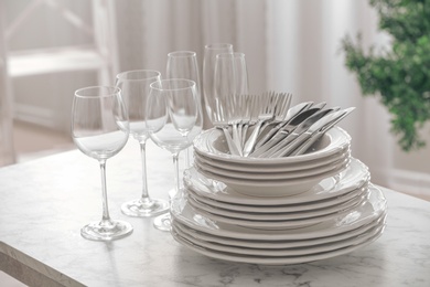 Set of clean dishware, cutlery and wineglasses on table indoors
