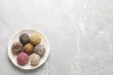 Delicious vegan candy balls on light grey marble table, top view. Space for text