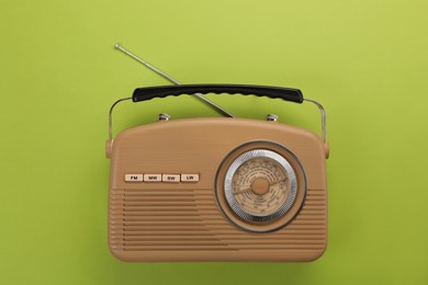 Retro radio receiver on light green background, top view