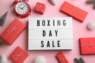 Lightbox with phrase BOXING DAY SALE and Christmas decorations on light pink background, flat lay