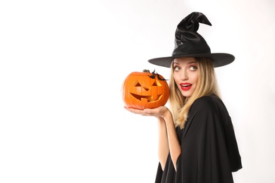 Beautiful woman in witch costume with jack o'lantern on white background, space for text. Halloween party