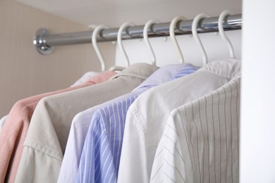 Photo of Collection of clothes in wardrobe, closeup view