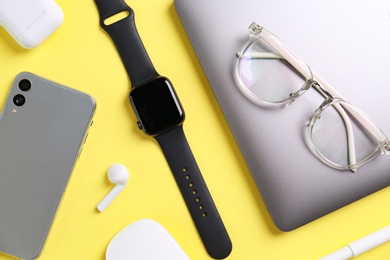 Flat lay composition with stylish smart watch on yellow background