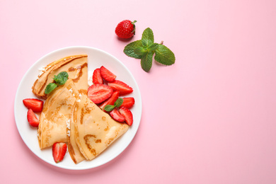 Photo of Delicious thin pancakes with strawberries and cottage cheese on pink background, flat lay. Space for text