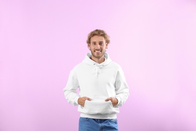 Photo of Portrait of man in hoodie sweater on color background. Space for design