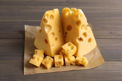 Pieces of delicious cheese on wooden table