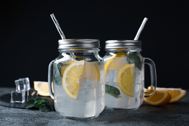 Delicious lemonade in mason jars on grey table