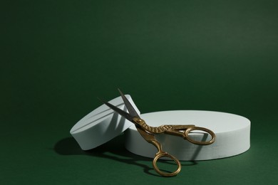 Photo of Product photography props. Round shaped podiums and vintage scissors on green background