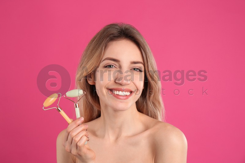 Photo of Young woman with natural face rollers on pink background
