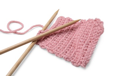 Pink knitting and wooden needles on white background, closeup