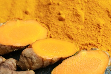 Photo of Turmeric powder and cut roots on table, closeup