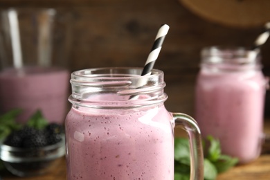 Tasty fresh milk shake with straw in mason jar, closeup