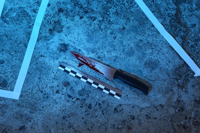 Photo of Crime scene with blood knife and ruler on floor, flat lay. Detective investigation