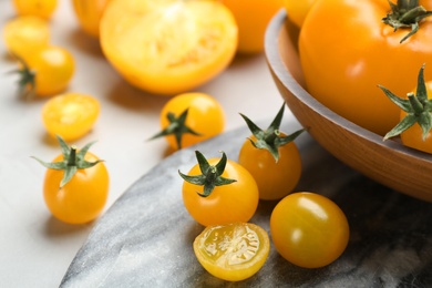 Ripe yellow tomatoes on marble board, closeup
