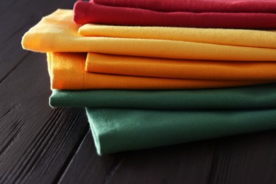Different colorful napkins on wooden table, closeup