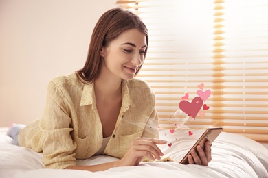 Image of Young woman visiting dating site via smartphone indoors