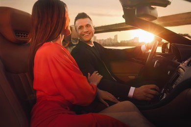 Photo of Beautiful couple in luxury convertible car outdoors