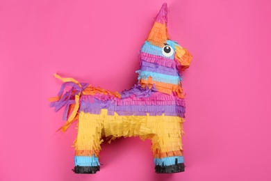 Photo of Bright donkey pinata on pink background, top view