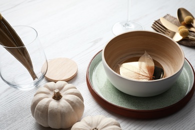 Autumn table setting with pumpkins on white wooden background