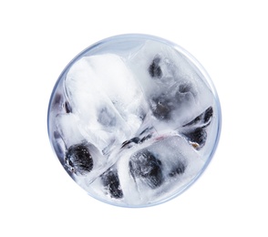 Glass of drink with blueberry ice cubes on white background, top view