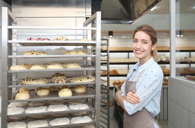 Baker at rack with pastries in workshop