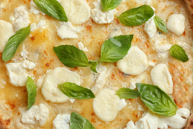 Photo of Delicious hot cheese pizza with basil as background, top view