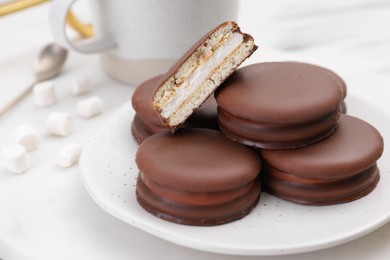 Saucer with delicious choco pies on white table, closeup