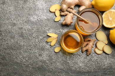 Ginger and other natural cold remedies on grey table, flat lay. Space for text