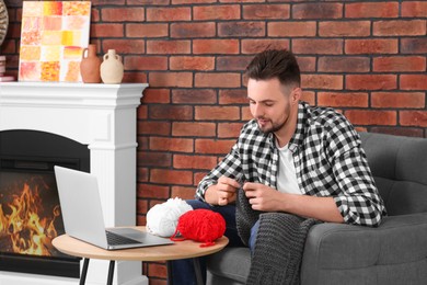 Photo of Man learning to knit with online course at home. Time for hobby