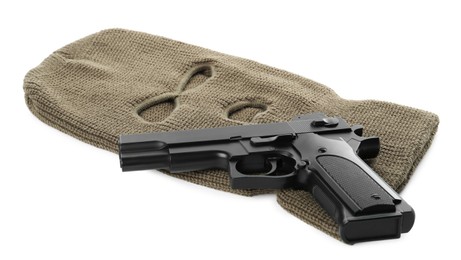 Photo of Beige knitted balaclava and pistol on white background