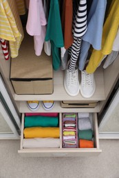Photo of Wardrobe with organized clothes and shoes indoors, above view. Vertical storage