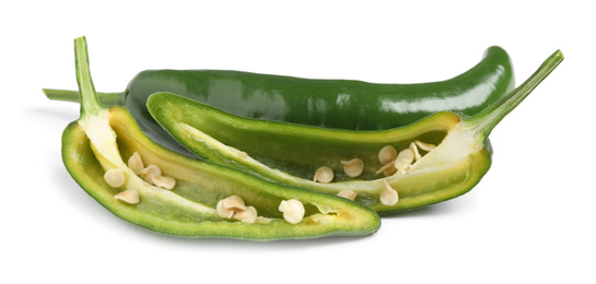 Photo of Cut and whole green hot chili peppers on white background