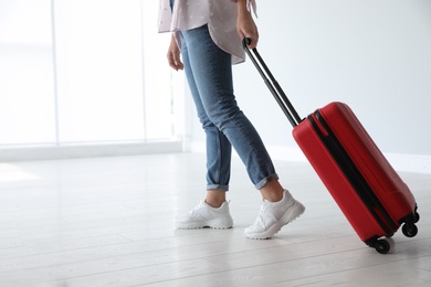 Woman with red travel suitcase in airport