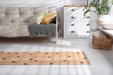 Stylish rug with dots on floor in living room
