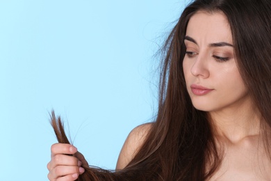 Photo of Woman with damaged hair and space for text on color background. Split ends