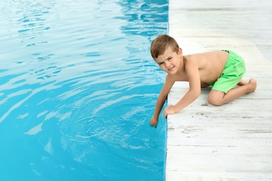 Little child near outdoor swimming pool. Dangerous situation
