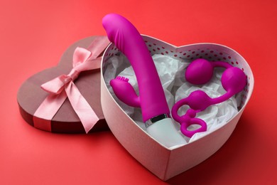 Gift box with sex toys on red background