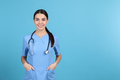Portrait of medical assistant with stethoscope on color background. Space for text